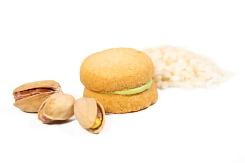 Baci-Piastacchio-Valerio-Volpe-Pasticceria-e-Sfizi-Oriz Baci di Dama con mandorla di Sicilia prodotto nel territoprio di Avola e Farina di Riso Vercellese con cioccolato bianco aromatizzato all'arancia e cannella